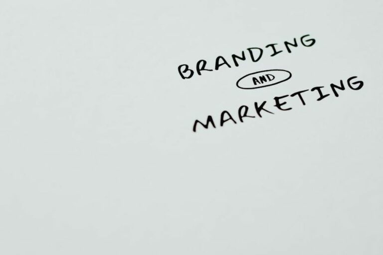 כיתוב 'Branding and Marketing' בכתב יד על דף לבן למיתוג ושיווק.
